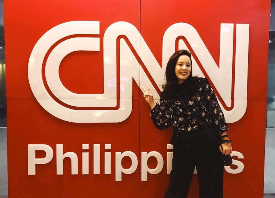 Victoria Herrera posing in front of a CNN Philippines sign