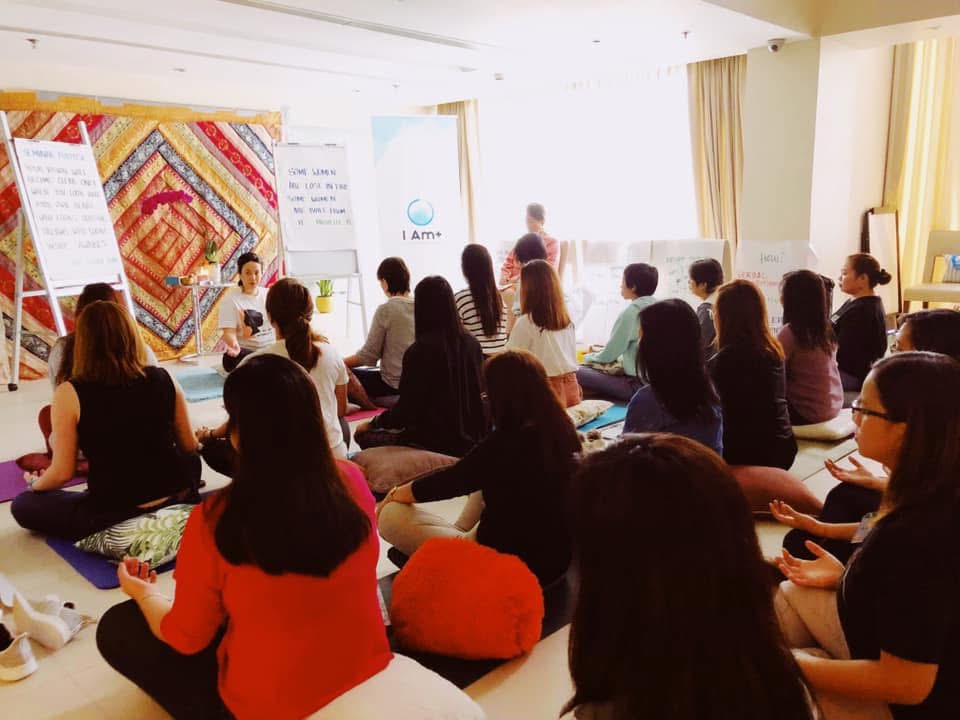 Victoria facilitating a workshop with participants seated on cushions